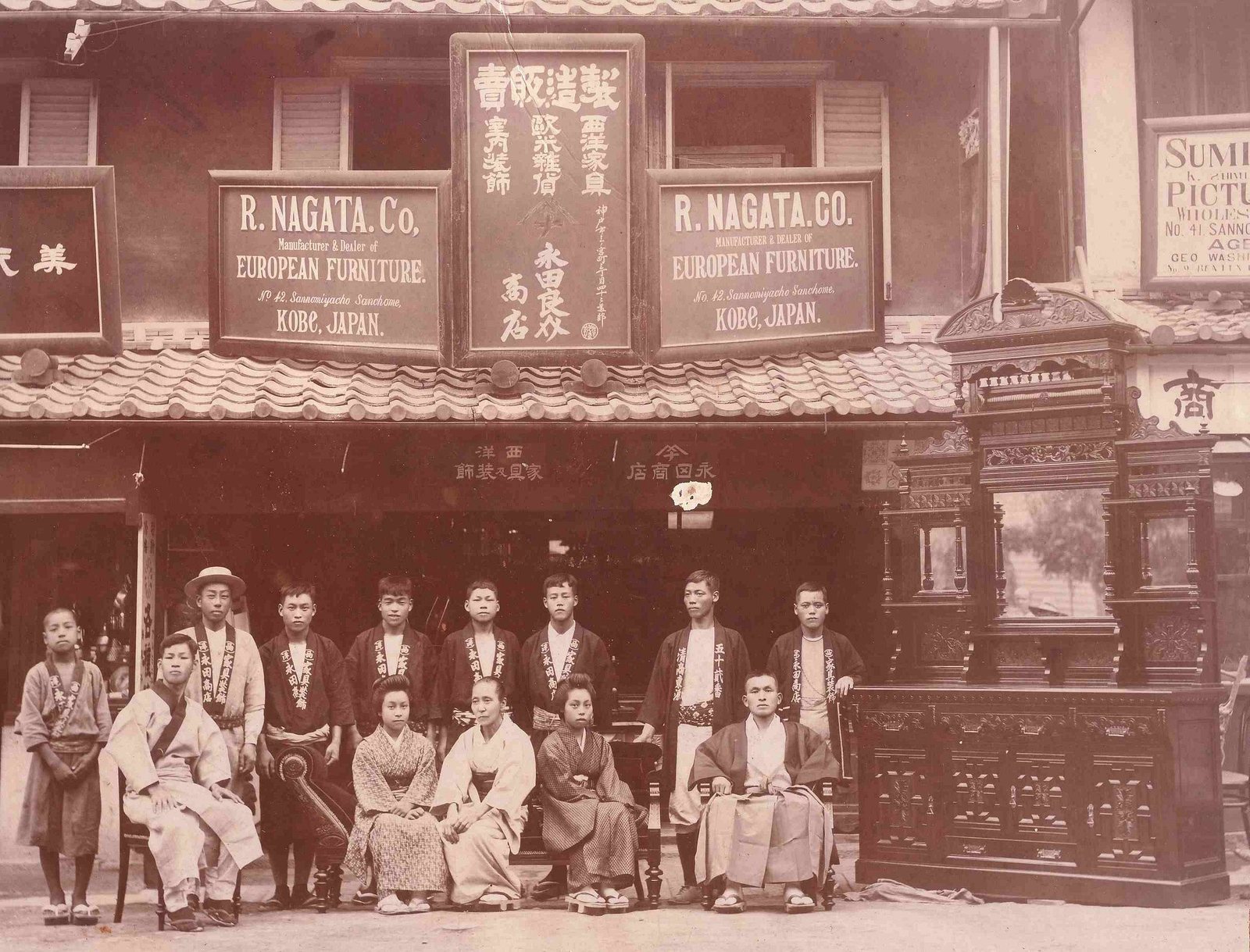 Historical sepia photograph of the R. Nagata & Co. storefront, with staff standing in front of the shop